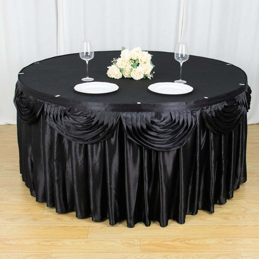 Elegant black tablecloth with pleats and floral centerpiece on round table.