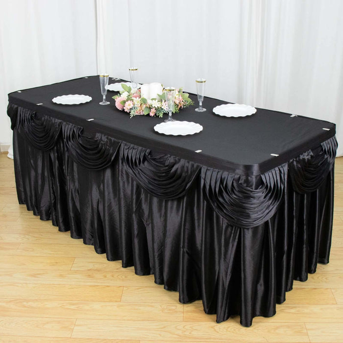 Black table skirt with elegant draping for event decoration.