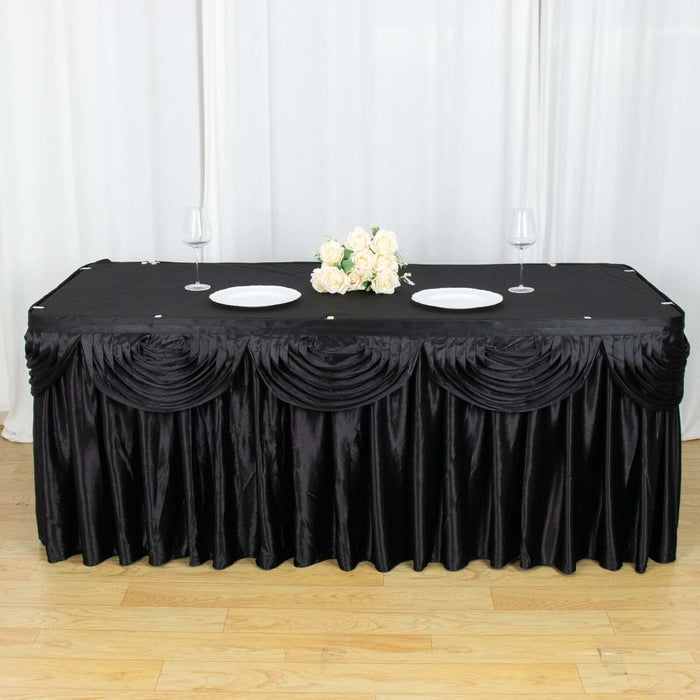 Black tablecloth with elegant pleats and floral centerpiece, perfect for events.