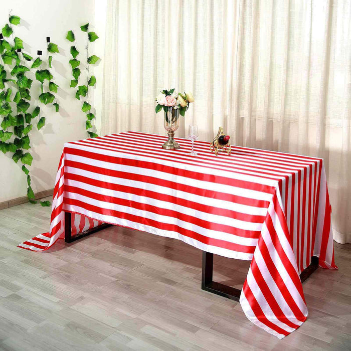 Red and white striped tablecloth on a dining table with floral centerpiece.