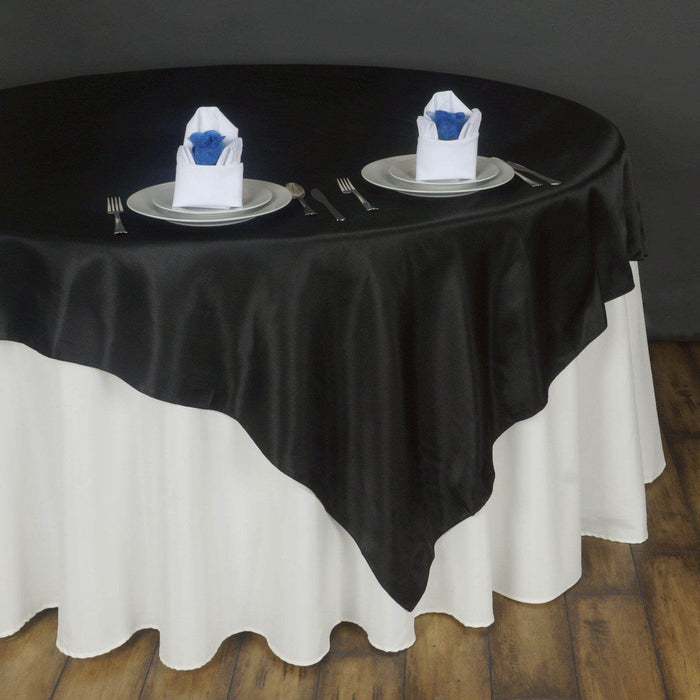 Elegant black and white tablecloth set for dining with decorative napkins.