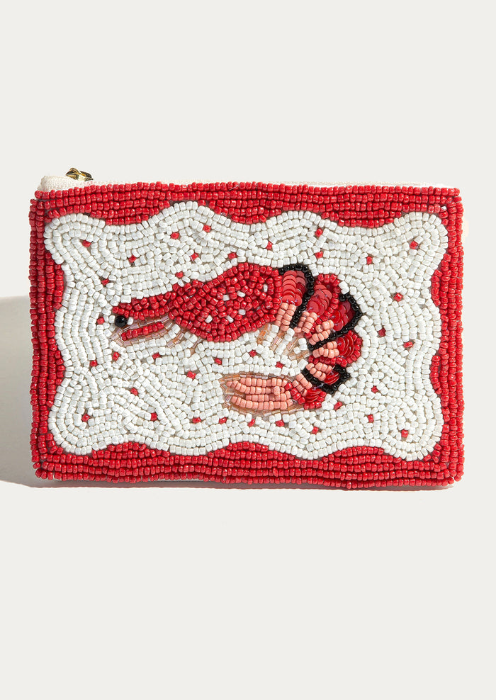 A beaded coin pouch with red shrimp inside of white squiggle border.