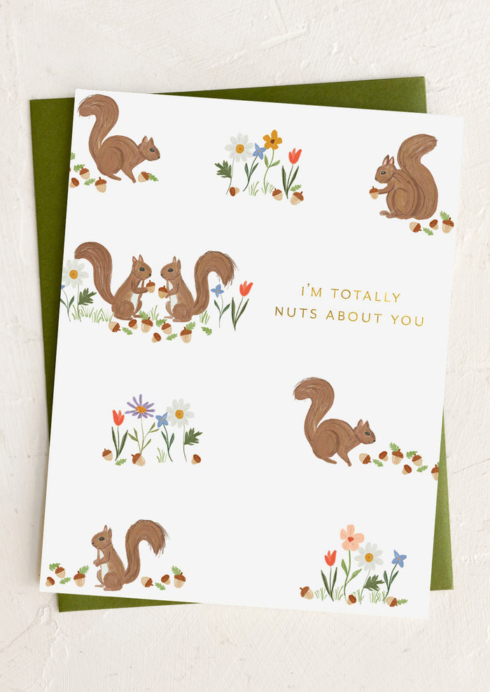 Greeting card with squirrels and flowers and text 'I'm totally nuts about you' on a white background.