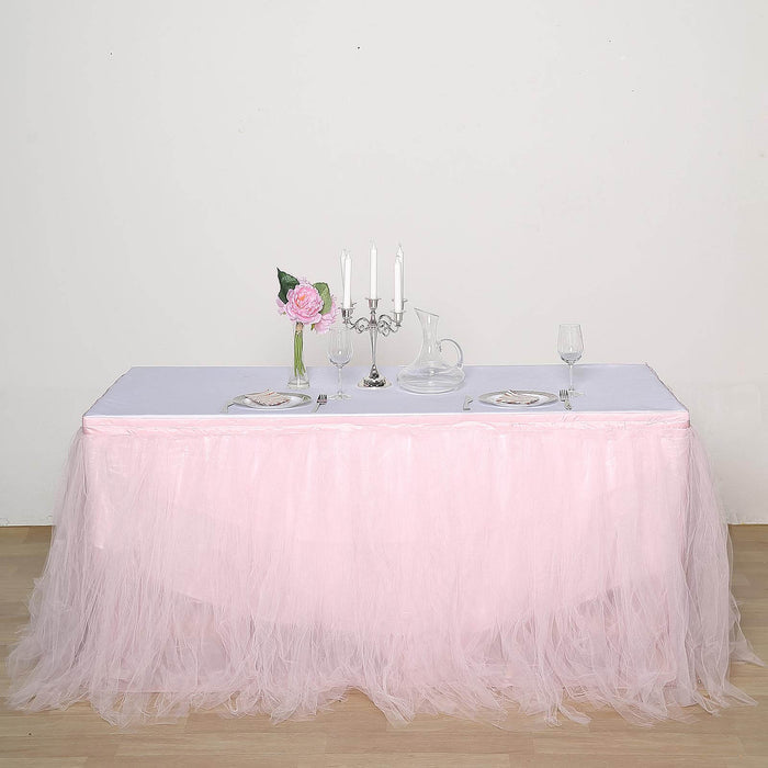 Elegant table setting with pink tulle skirt, candles, and floral centerpiece.