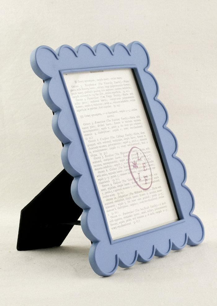 A powder blue 5" x 7" picture frame with a scalloped design.